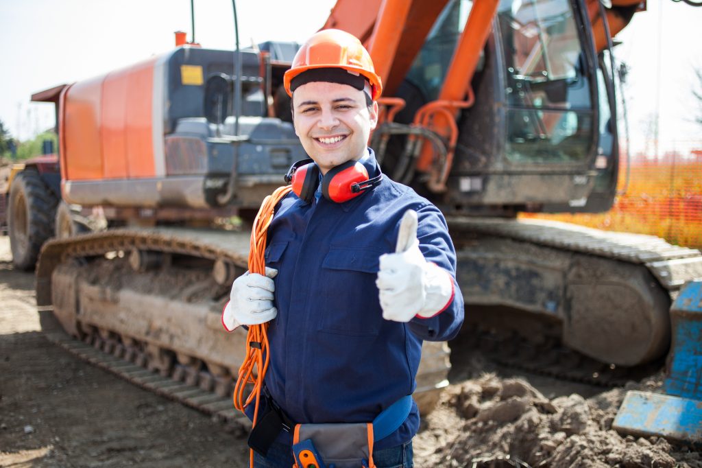 A happy worker in a construction site, ready for reinstatement works.